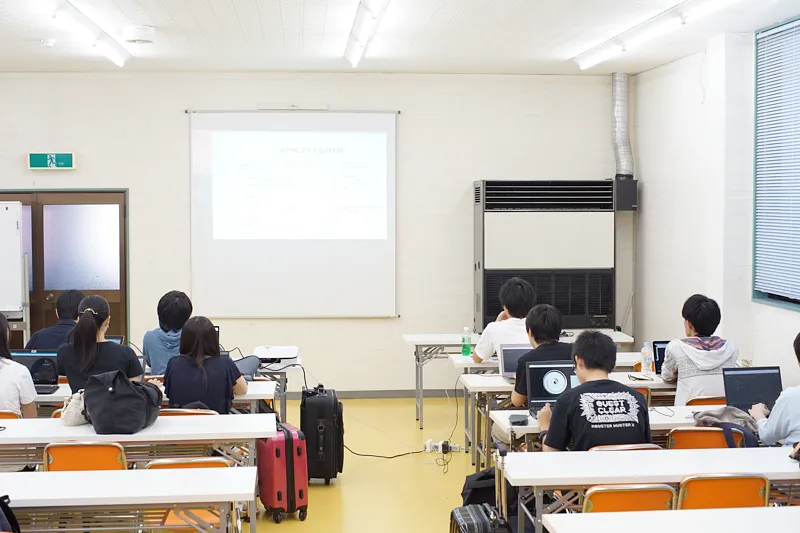 教室に複数の人の生徒が座っている写真